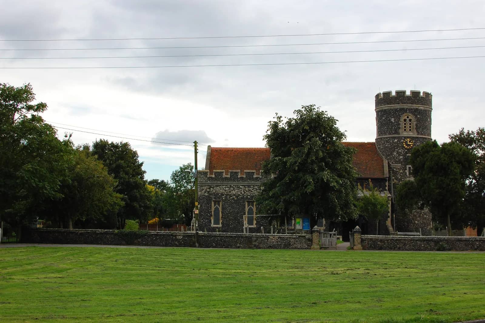 St Nicholas Church in South Ockendon, with its round flint tower, seen across the village green