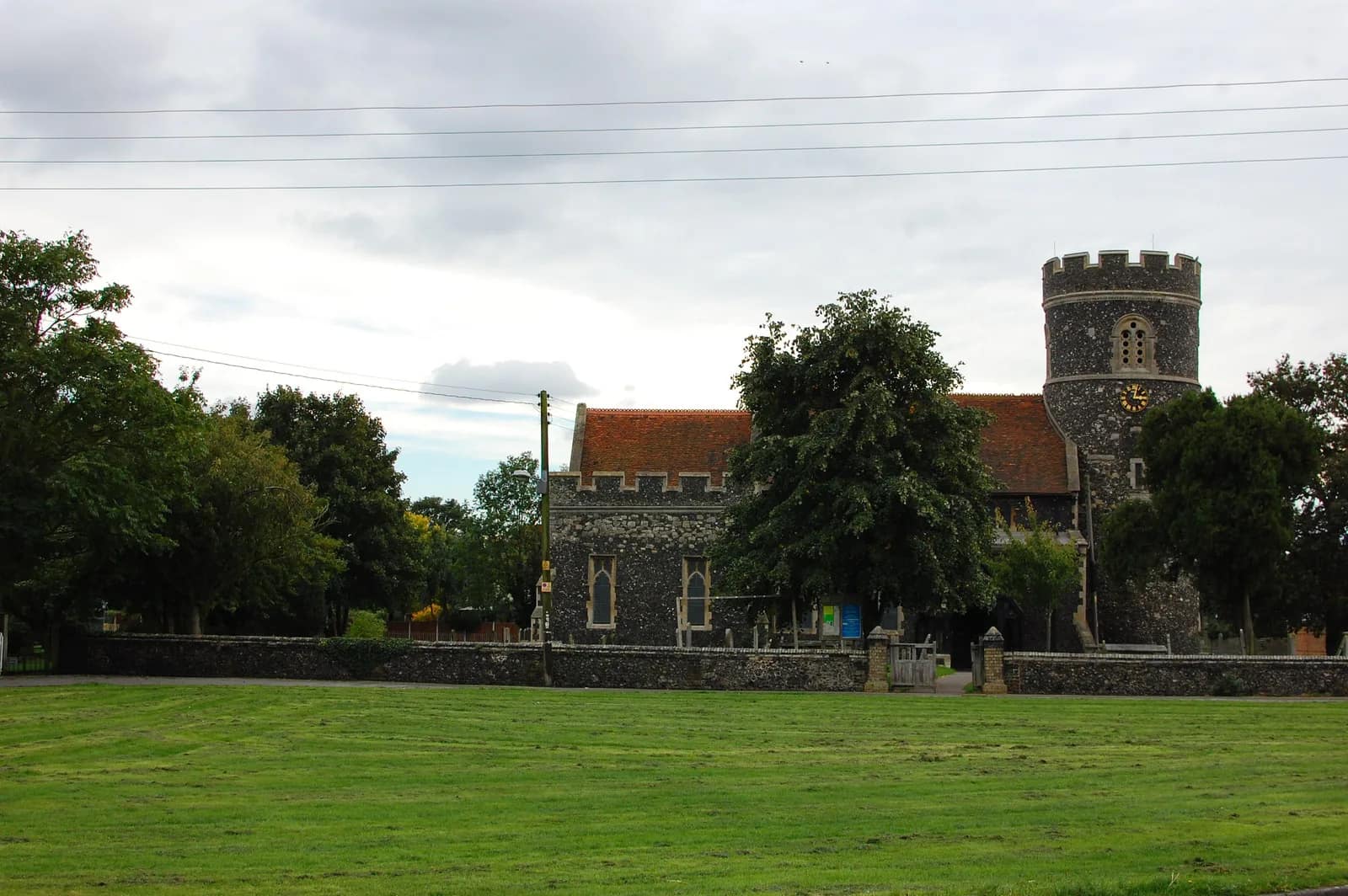 St Nicholas Church in South Ockendon, with its round flint tower, seen across the village green